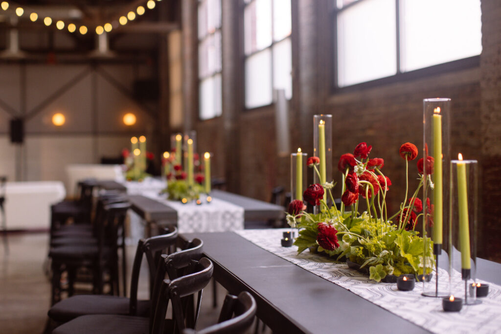 Red flowers and green candles atop a table at a Philadelphia networking event.