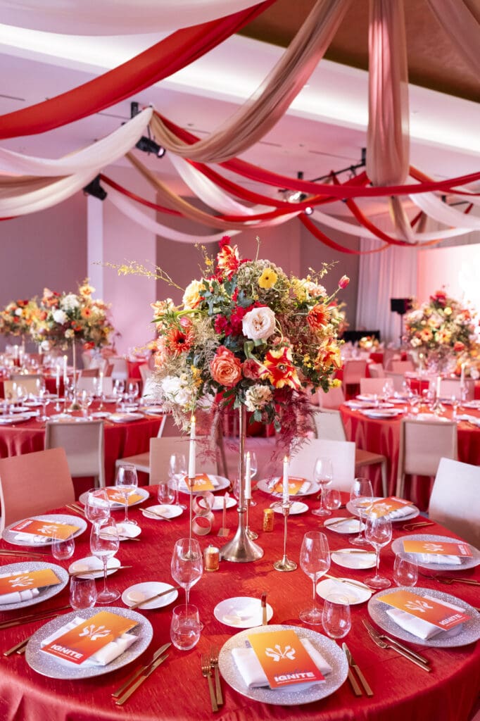 Fiery red floral centerpieces to compliment tables for a corporate dinner event.