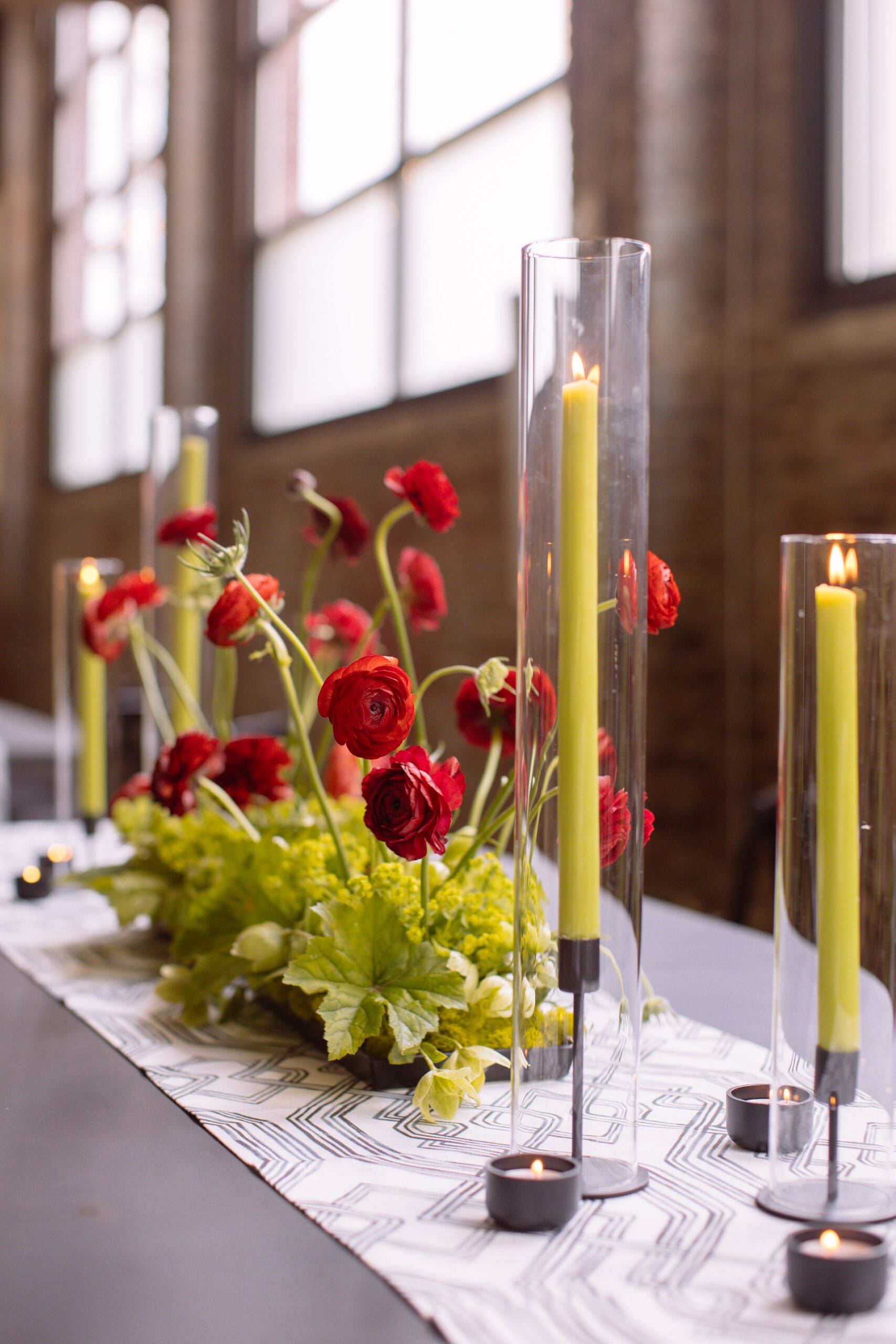 Red floral arrangements atop tables at the Philadelphia WIPA's corporate event.