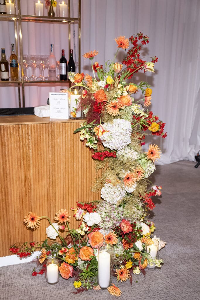 Fall floral arrangement with vibrant blooms cascading elegantly down the bar, adding seasonal charm to the setup.