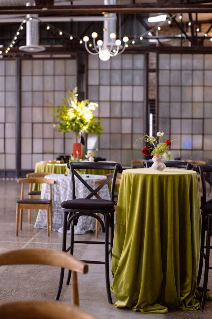 Red floral arrangements atop green velvet tables for a Philadelphia corporate event for WIPA.