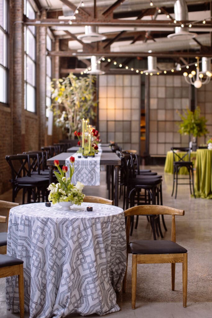 Red and white floral arrangements atop tables at a Philadelphia corporate event.