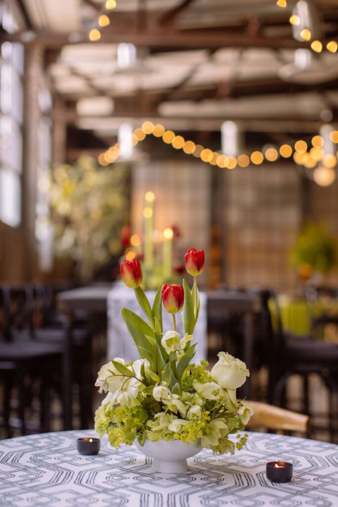 Red and white floral arrangement atop tables at a Philadelphia corporate event for WIPA.