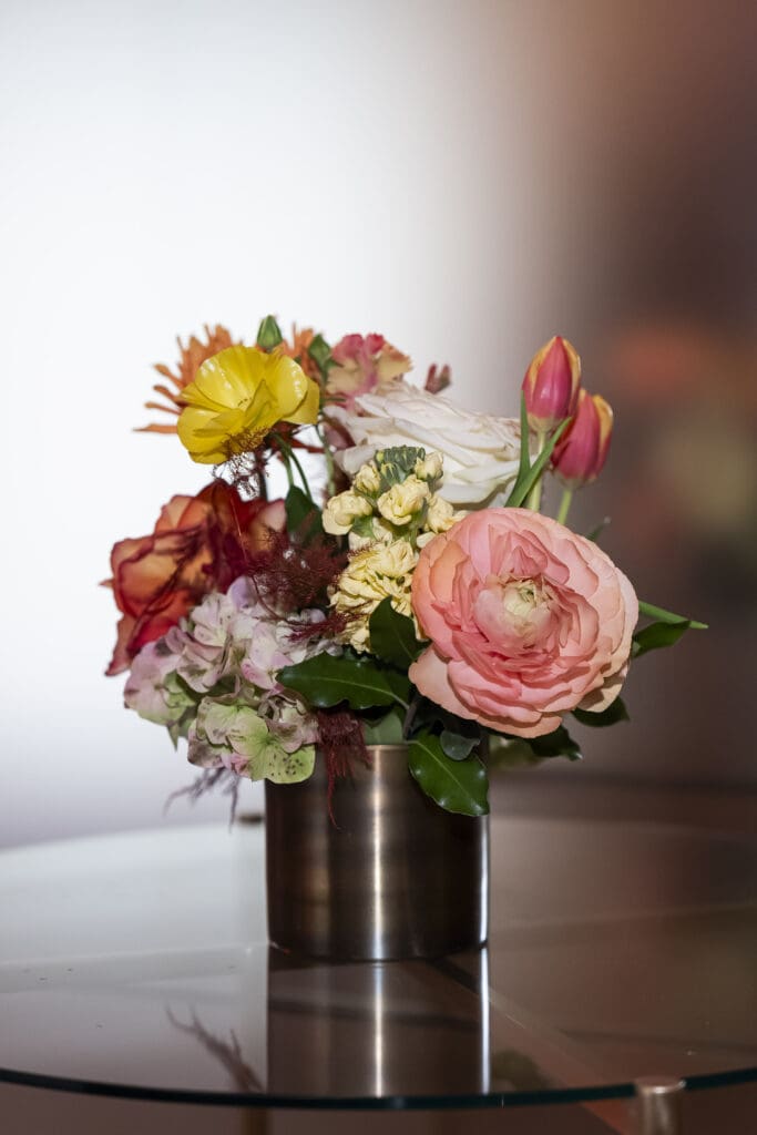 Close-up view of a small floral arrangement, highlighting delicate seasonal blooms and intricate design details.