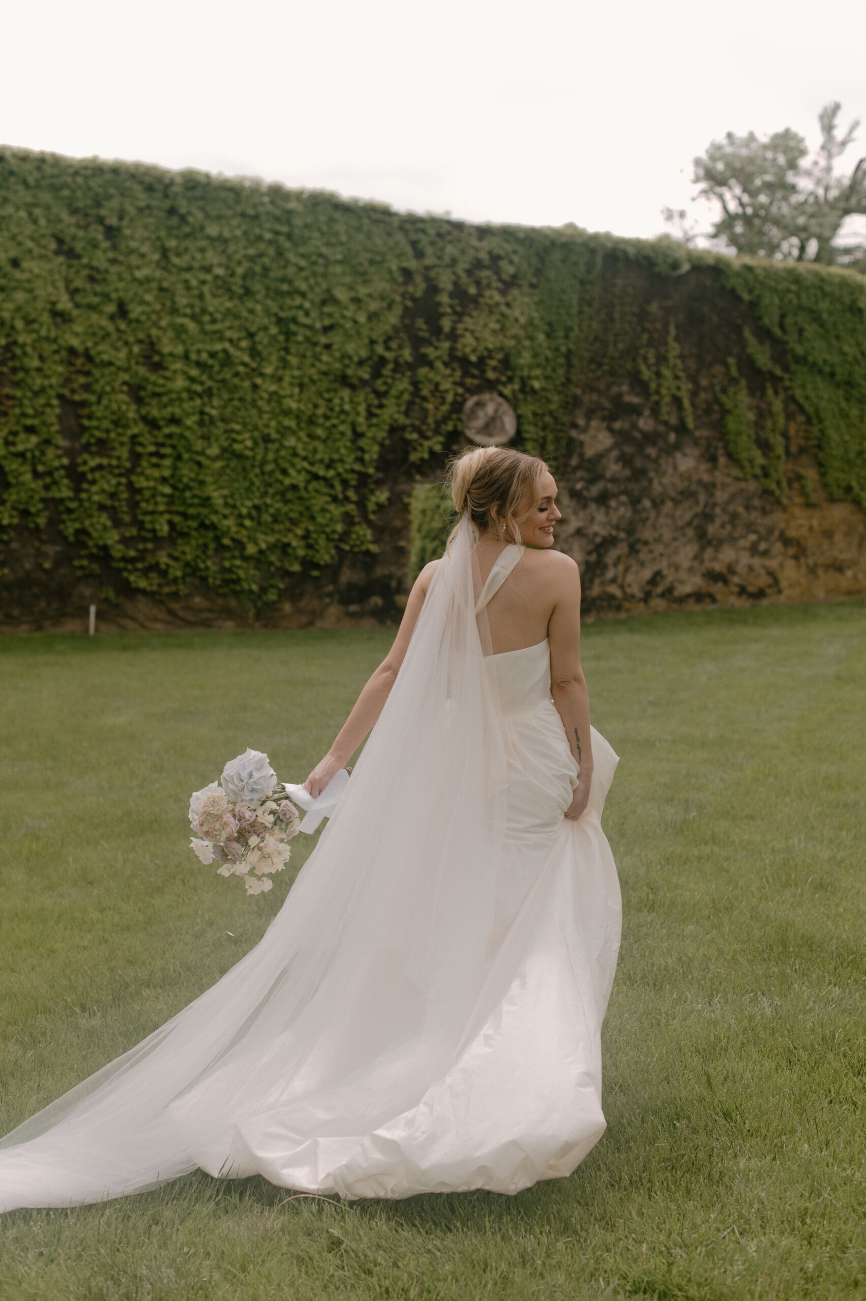 A radiant bride holding a stunning spring bouquet, her smile capturing the joy and beauty of the season on her unforgettable wedding day in Philadelphia.