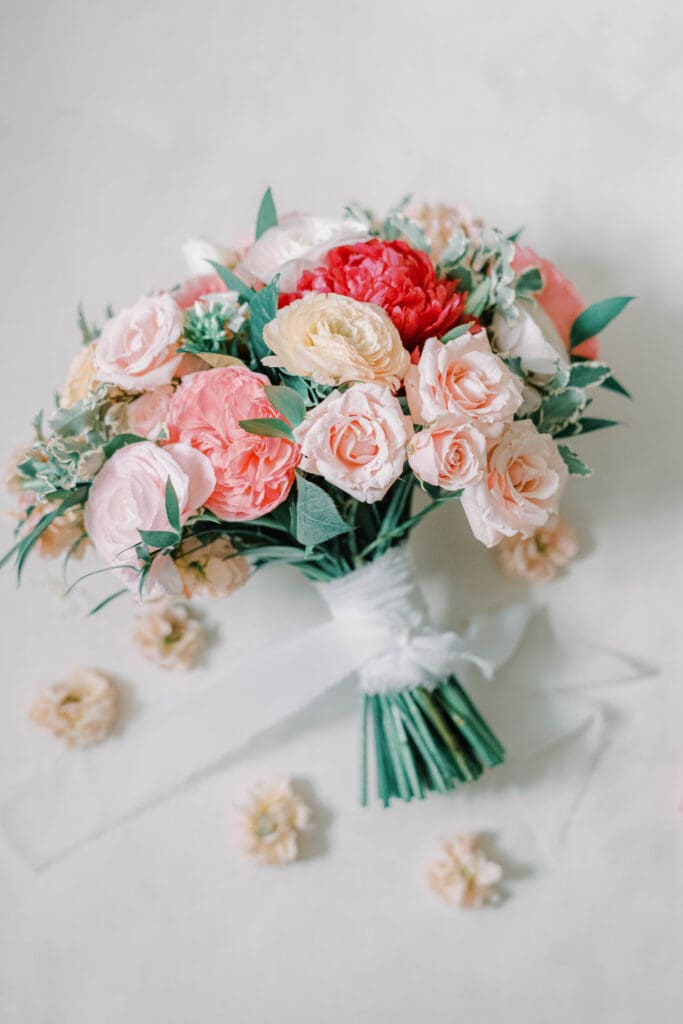 A stunning bridal bouquet featuring romantic Valentine’s Day hues of red, pink, and blush, accented with lush greenery.