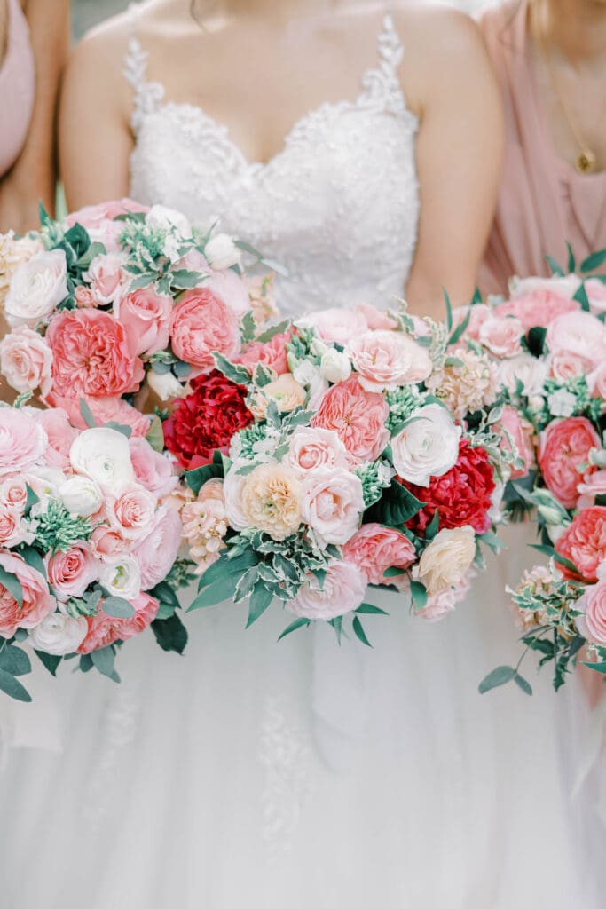 A radiant bride and her bridesmaids holding coordinating bouquets in Valentine’s Day colors, creating a picture-perfect moment of love and elegance.






